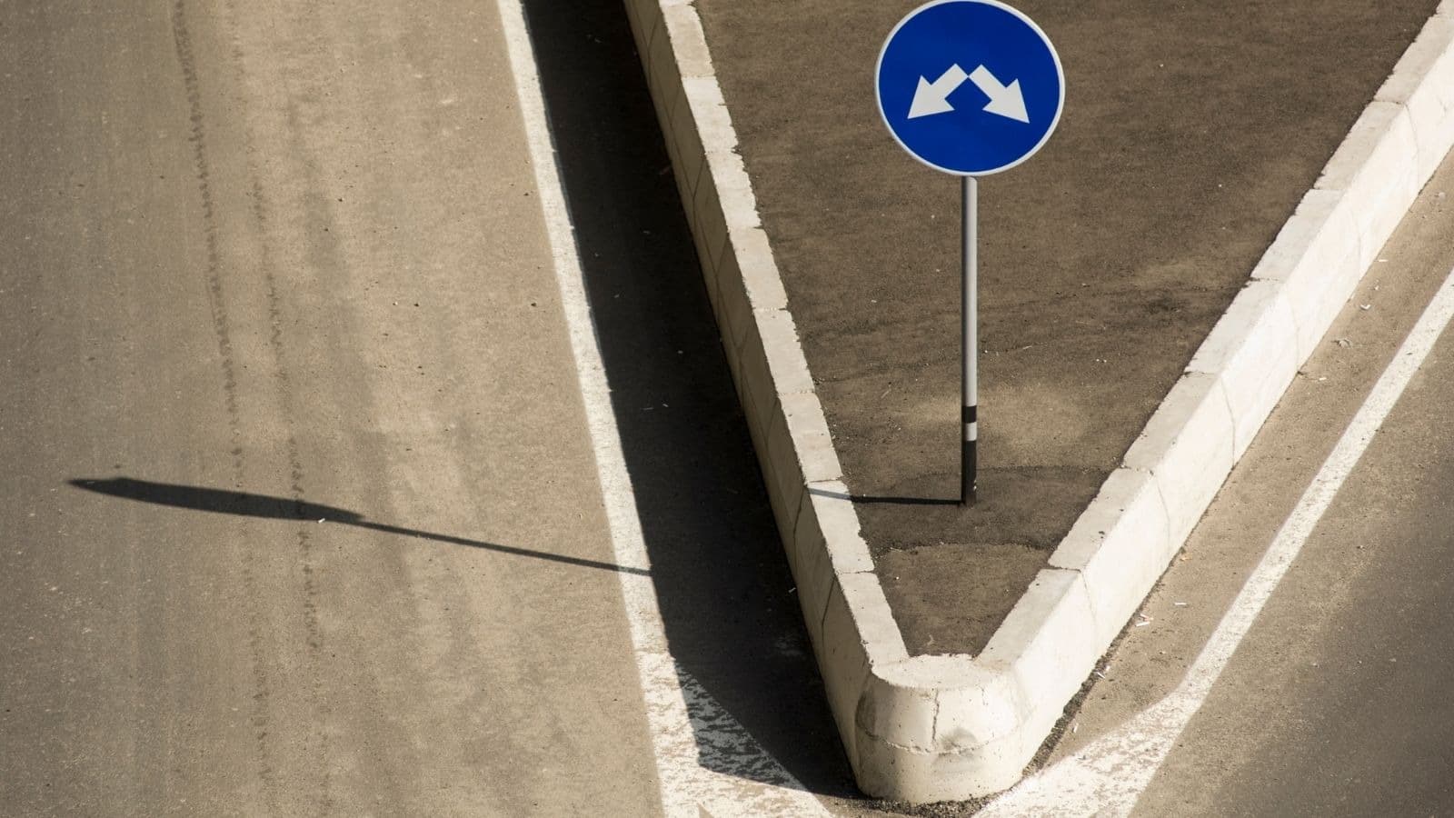 Route divisée autour d'un panneau à deux flèches